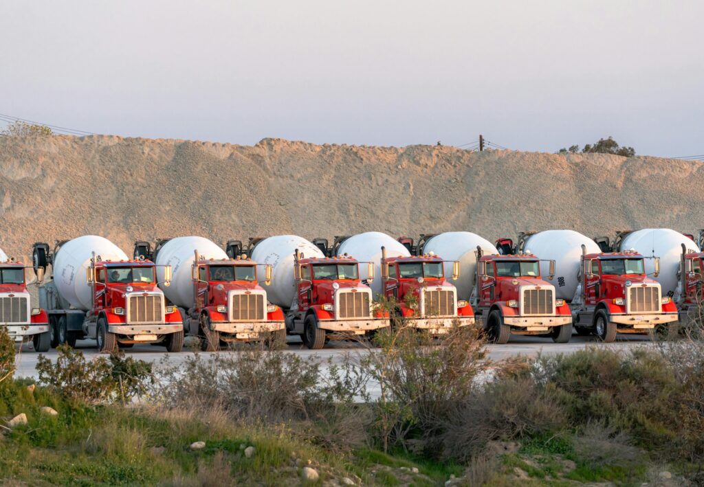 Red cement trucks lined up, showcasing industry and transport in Redlands, CA.
